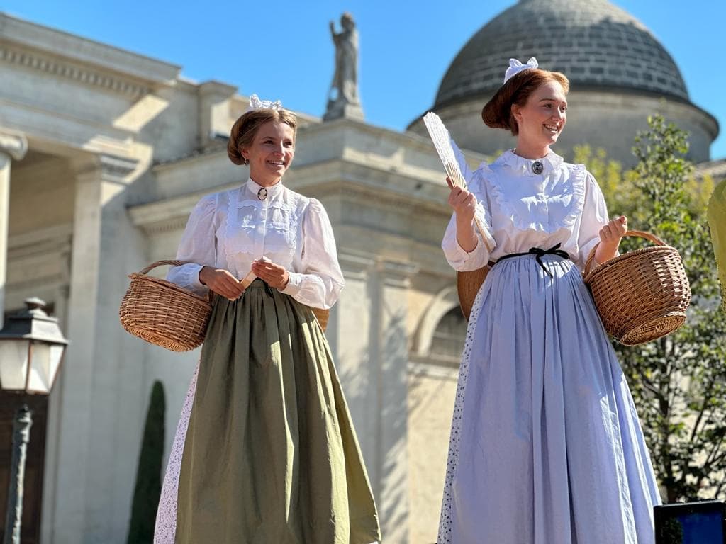 Deux femmes en tenue traditionnelle avec paniers.